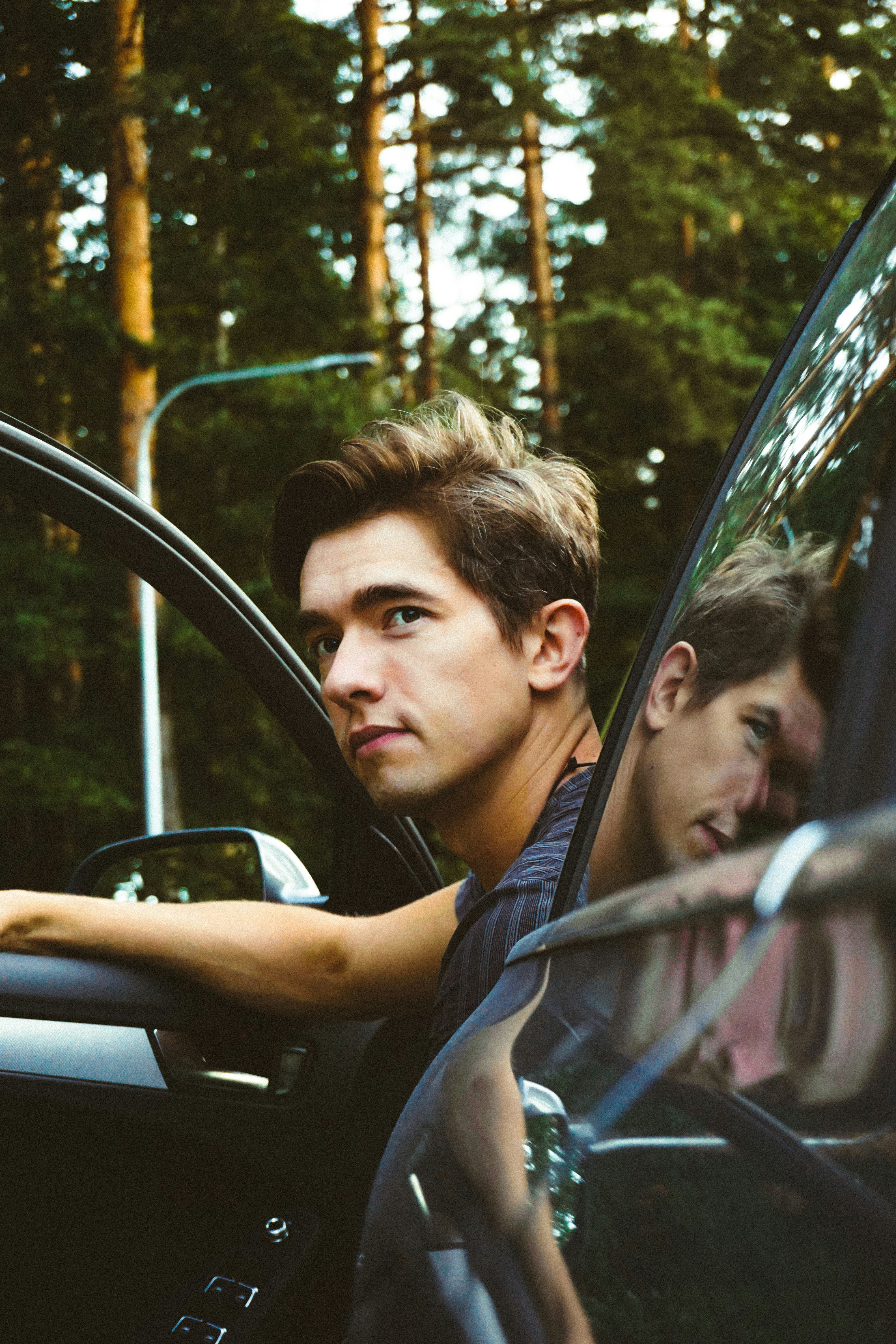 man in black shirt driving car during daytime